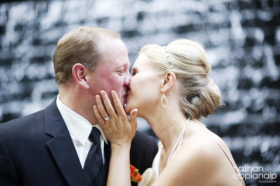 Bride and groom kissing in front of fountain in uptown Charlotte