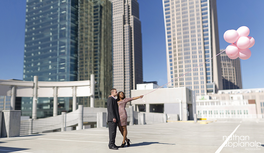 Couple holding pink balloons on a rooftop in uptown Charlotte NC