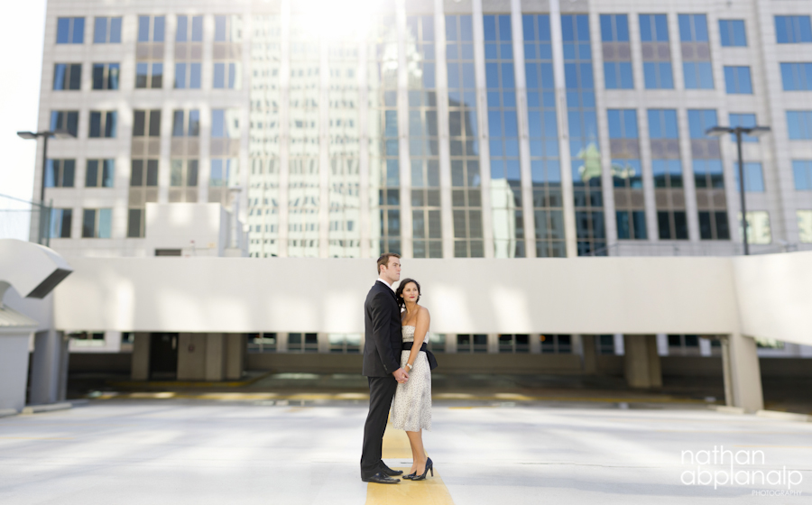 Couple embracing during an engagement session on a rooftop in uptown Charlotte NC