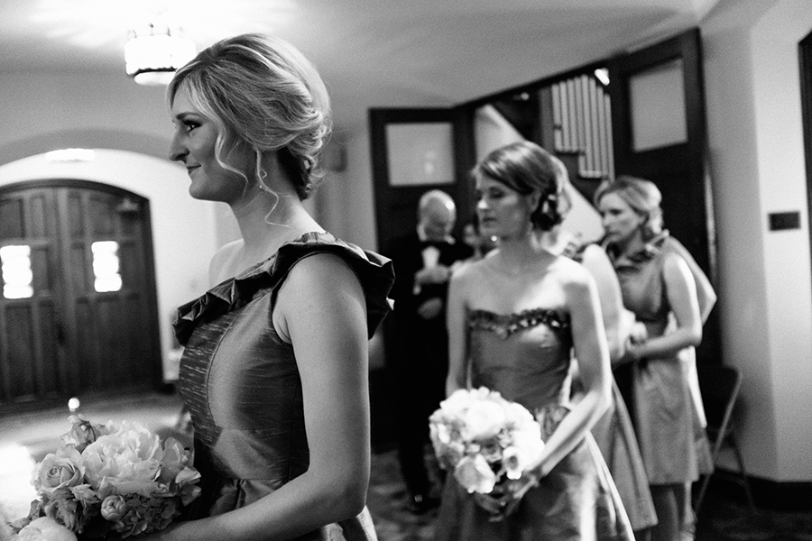 Bridesmaids look on as the bride dresses