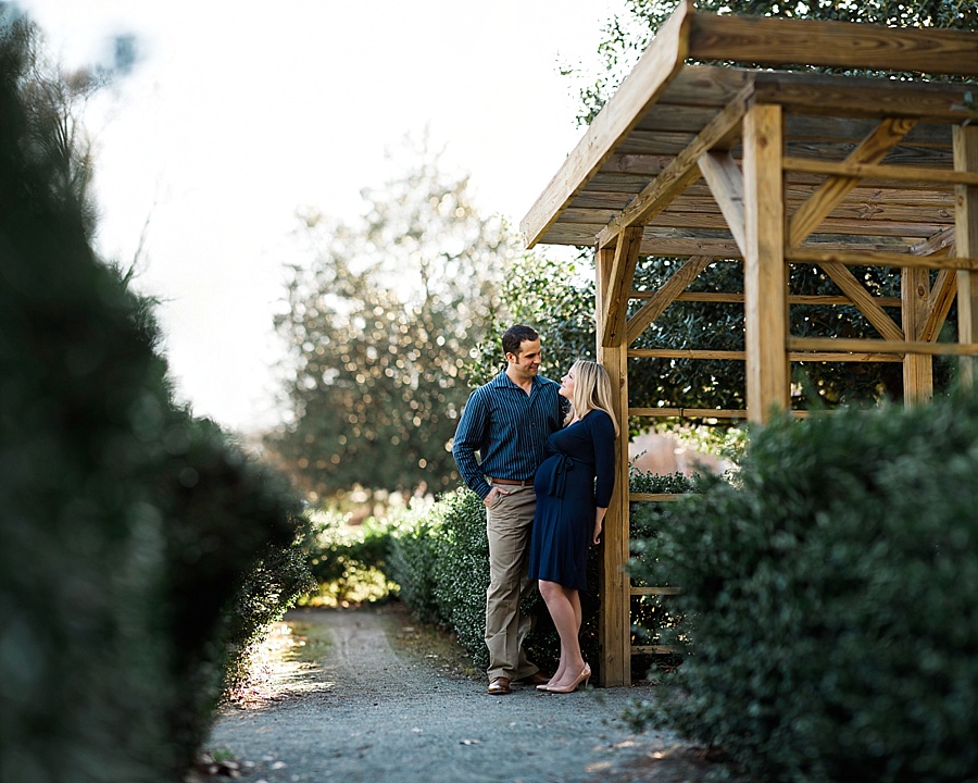 Husband and wife look at each other near the arbors at Independence Park in Charlotte NC