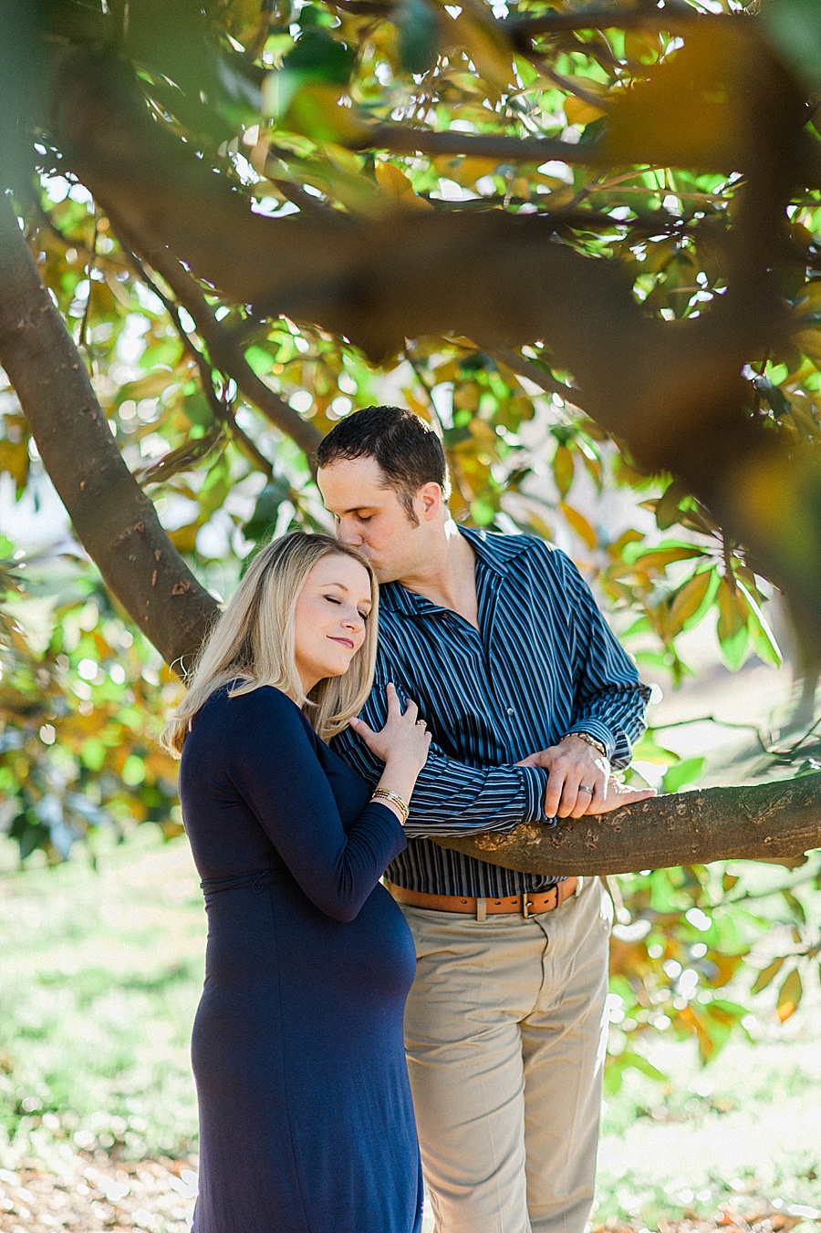Husband kisses wife on the head in Independence Park in Charlotte NC