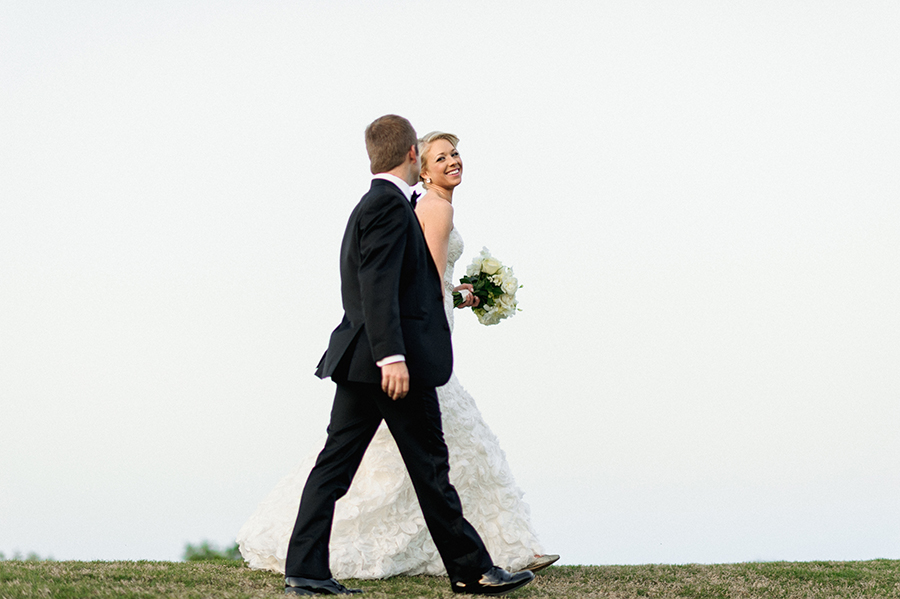 Bride and Groom walking on the green at the Carmel Country Club in Charlotte NC