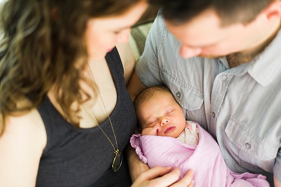 Newborn session with mother and father looking at baby in Charlotte NC