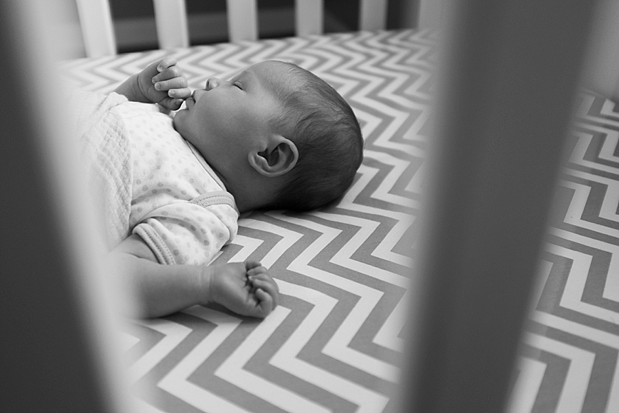 Newborn baby in crib with chevron sheets in Charlotte NC