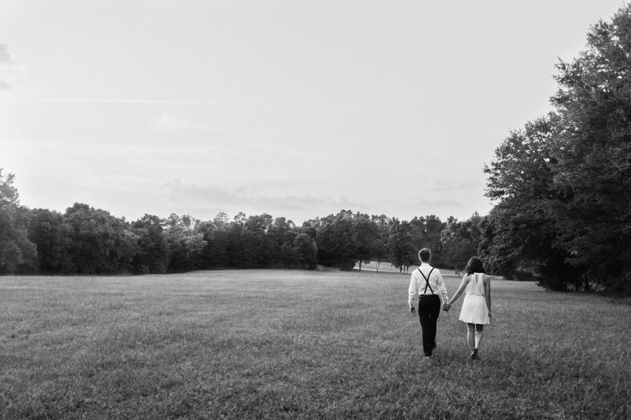 Couple walking hand in hand in field in Charlotte NC
