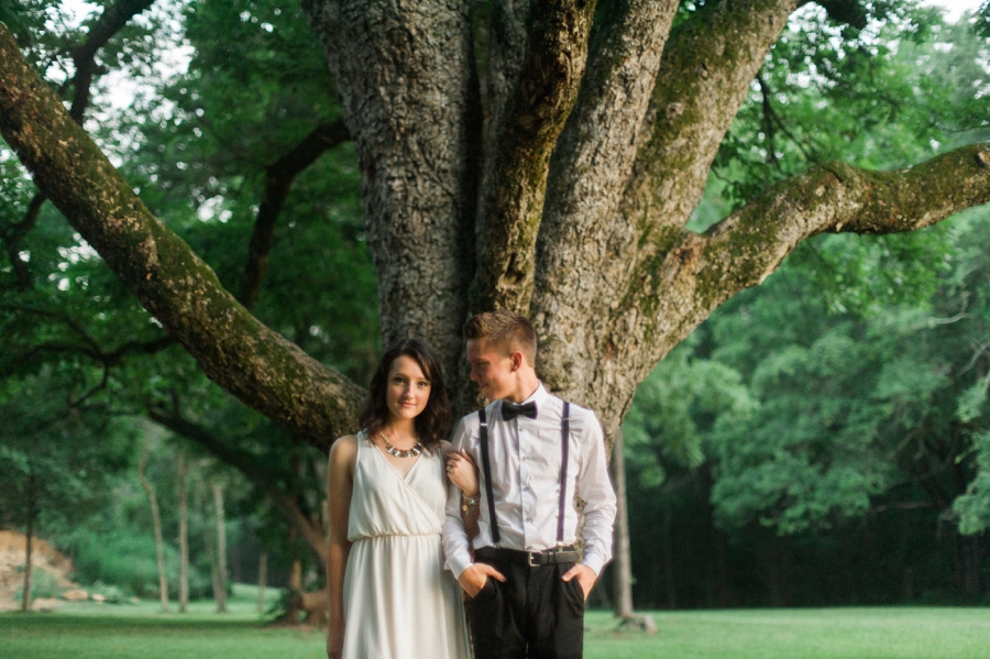 Future groom looks at his bride in front of large tree in Charlotte NC
