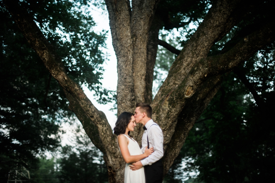 Man and woman embrace in front of large tree in Charlotte NC