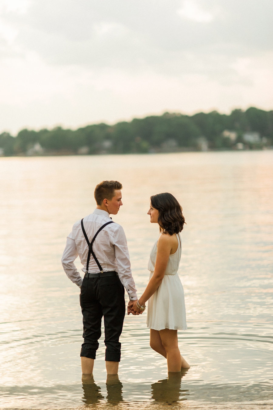 Couple holding hands on the shores of Lake Wylie in Charlotte NC