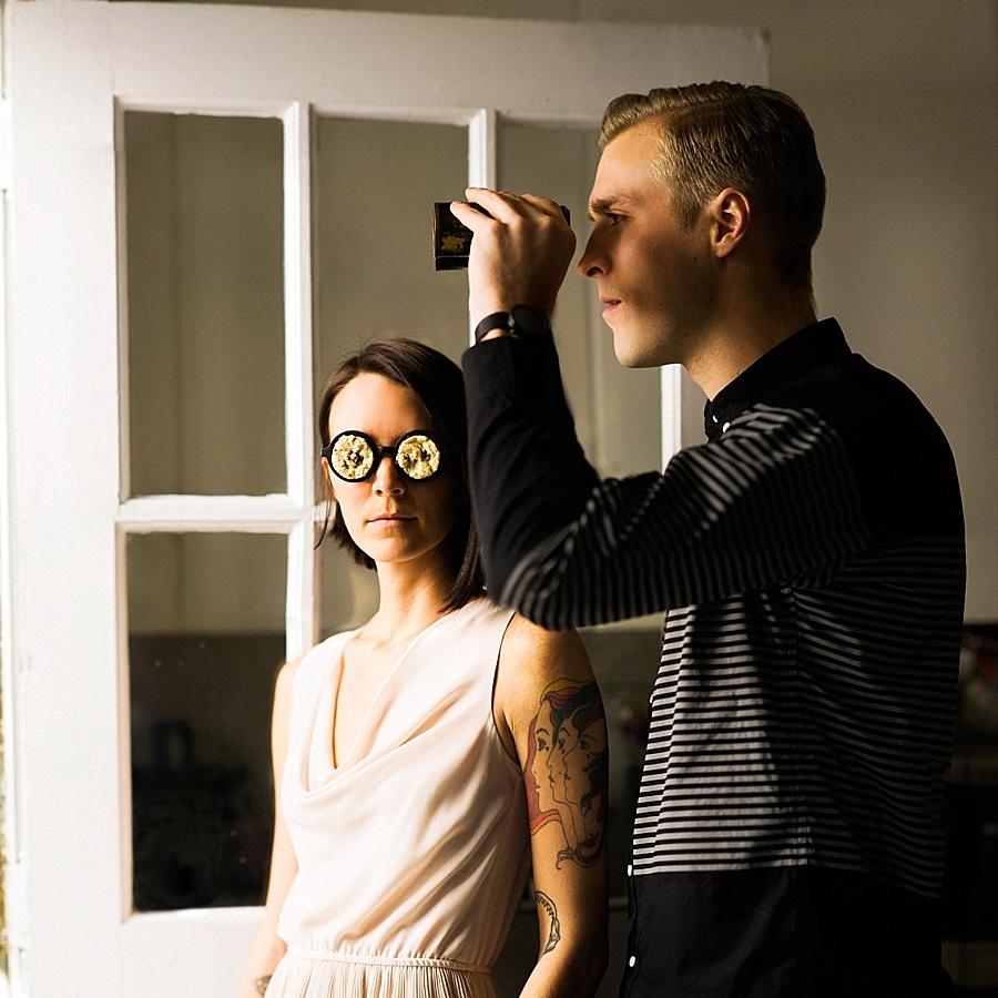 Man looking out a door with cookie binoculars and a women with cookie glasses for The Cookie Cult in Charlotte NC
