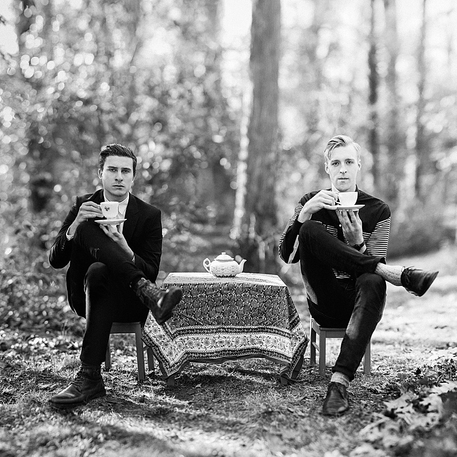Two men sitting in little chairs sipping tea for The Cookie Cult in Charlotte NC