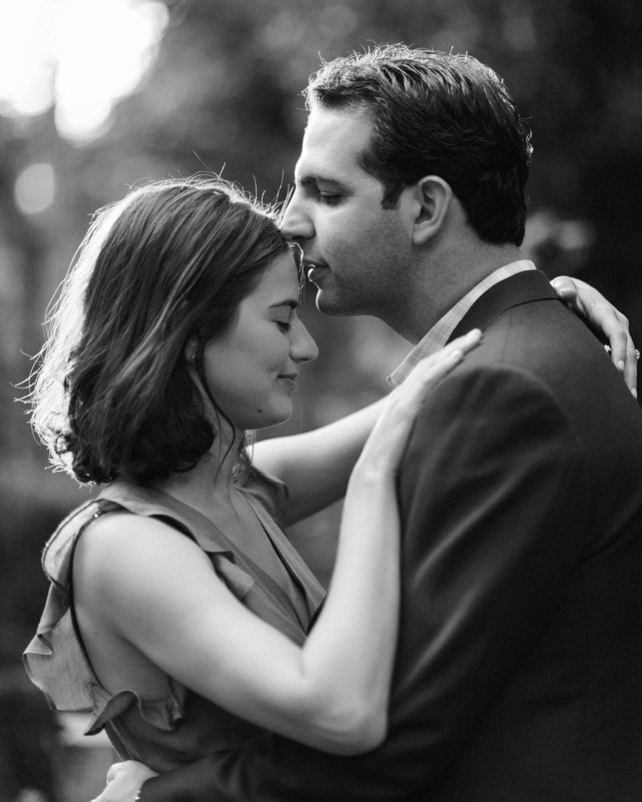 Man kissing woman's forehead at Wing Haven Gardens in Charlotte NC