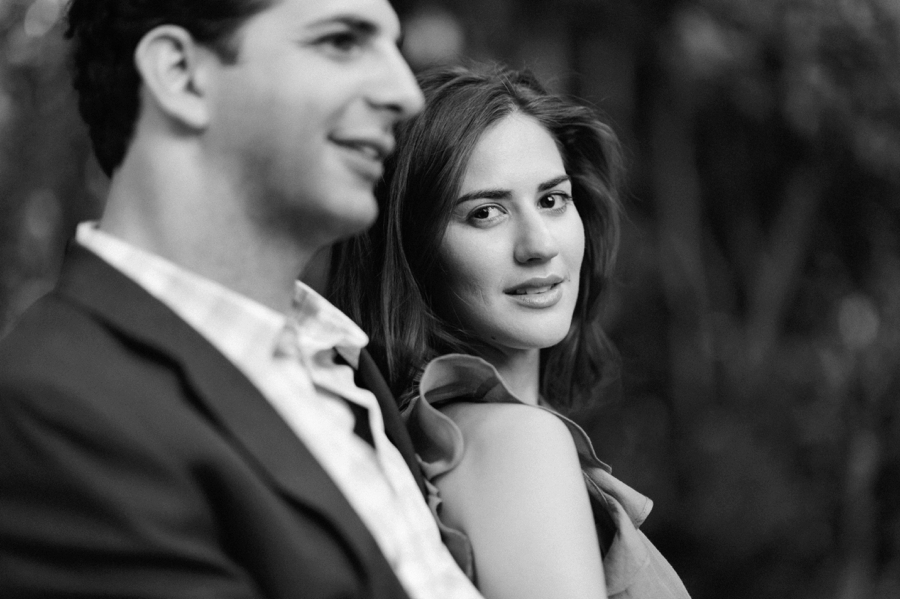 Woman leaning on man during engagement session at Wing Haven Gardens in Charlotte NC