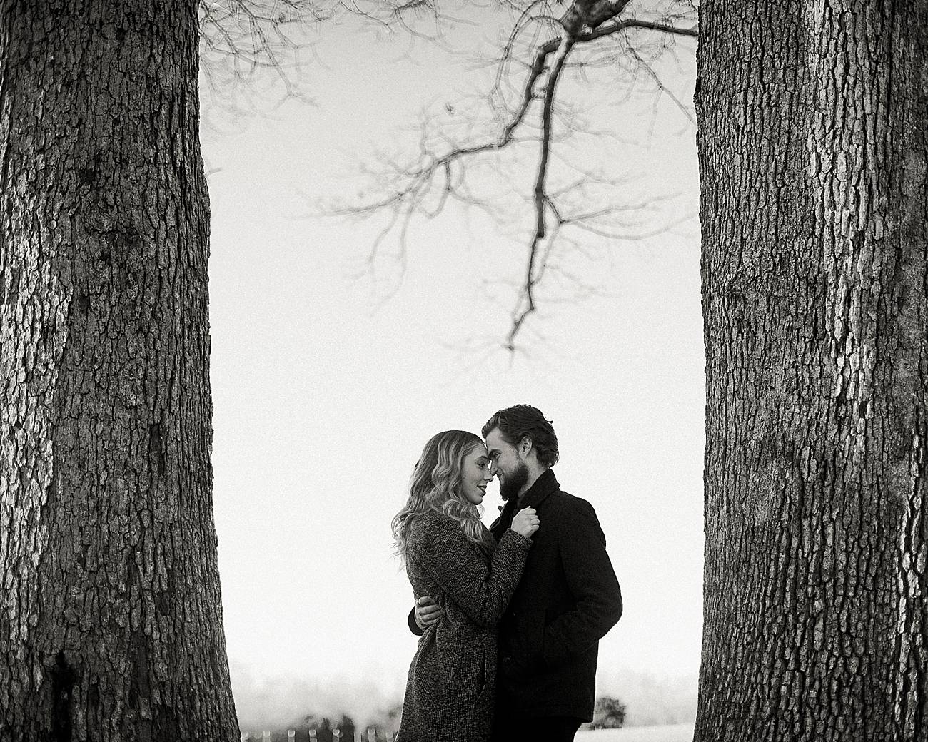 man and woman snuggle close between trees at Ann Springs Close Greenway
