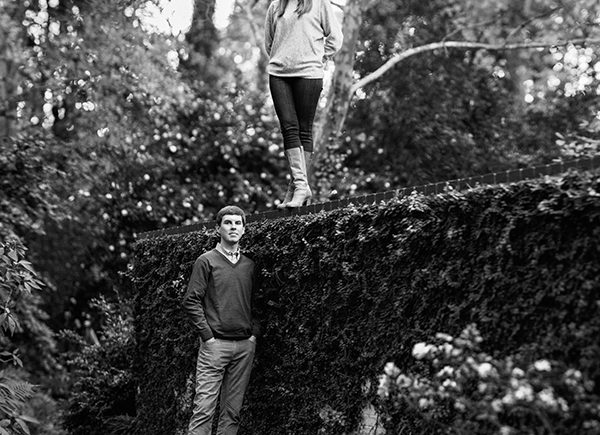 Woman standing on wall with finance during engagement photos in Myers Park Charlotte NC