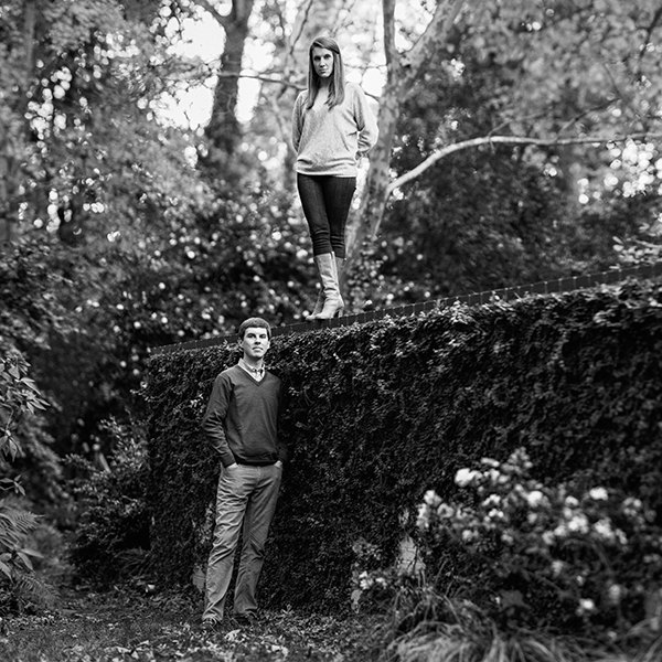 Woman standing on wall with finance during engagement photos in Myers Park Charlotte NC