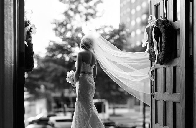 Bride with sweeping veil standing in the doorway of the First United Methodist Church in Charlotte NC