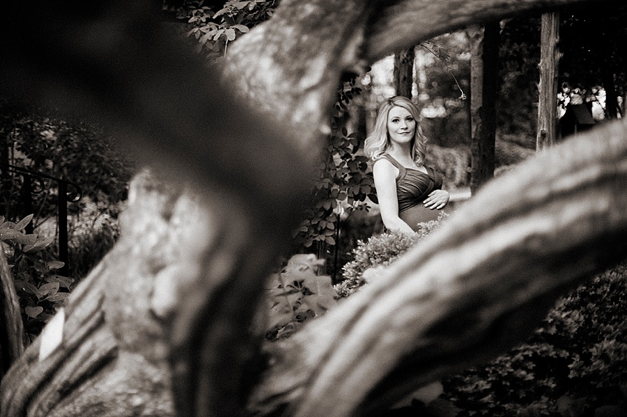 Expectant mother poses for maternity photos at Wing Haven Gardens in Charlotte NC