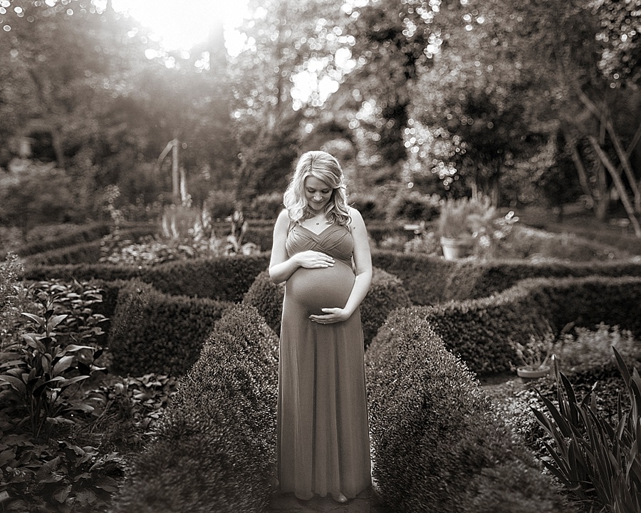 Mother poses for maternity photos at Wing Haven Gardens in Charlotte NC