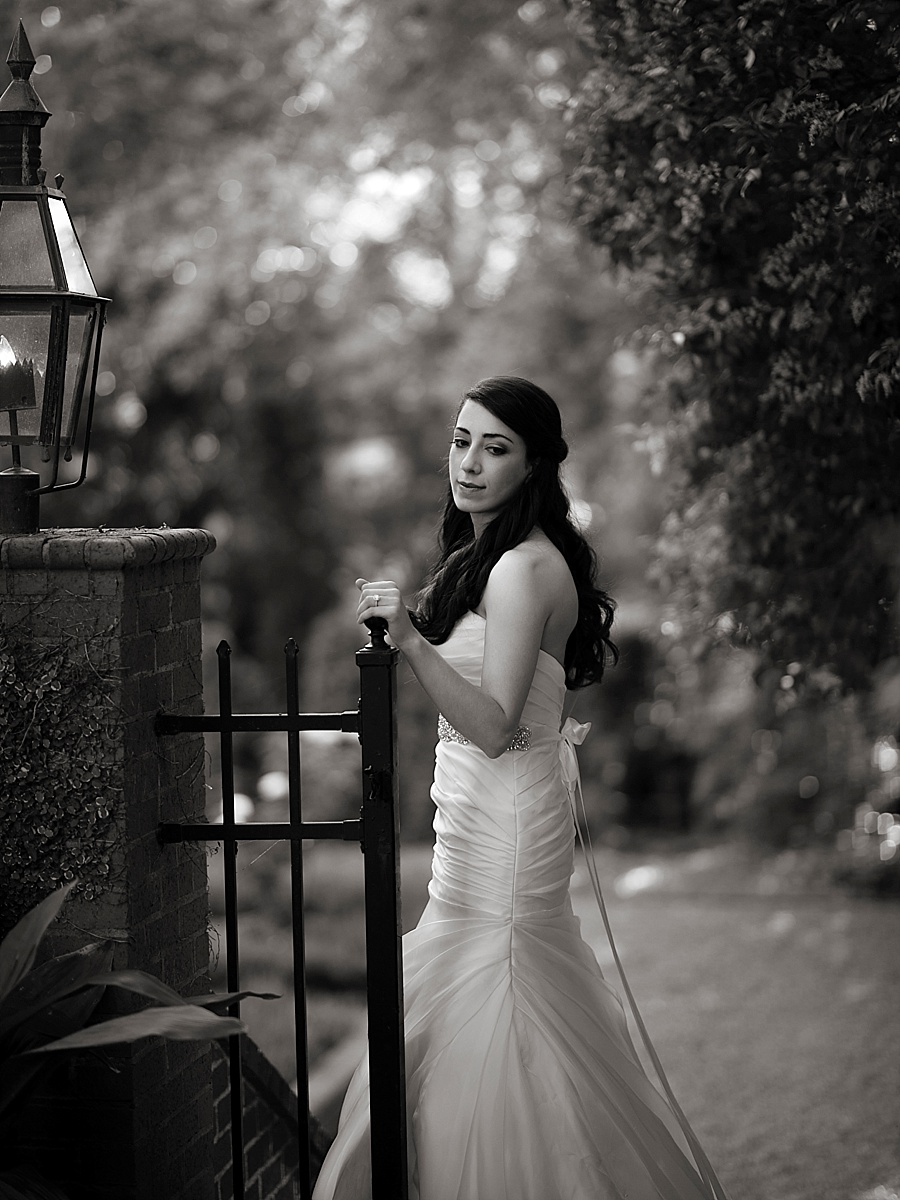 B&W of bride standing at gate of the Duke Mansion in Charlotte NC