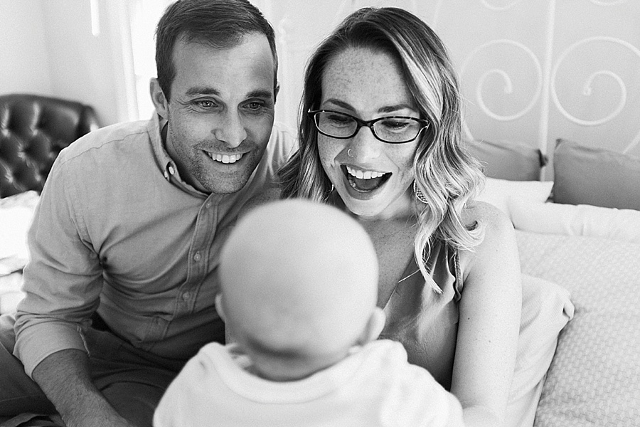 Mother and Father make faces at baby during a family session in Charlotte nC
